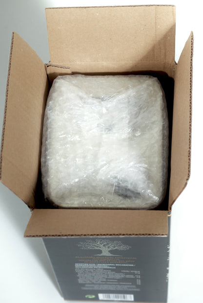 open cardboard shipping box viewed from above showing a Euphoria Gift 5L tin securely wrapped in bubble wrap for safe delivery."